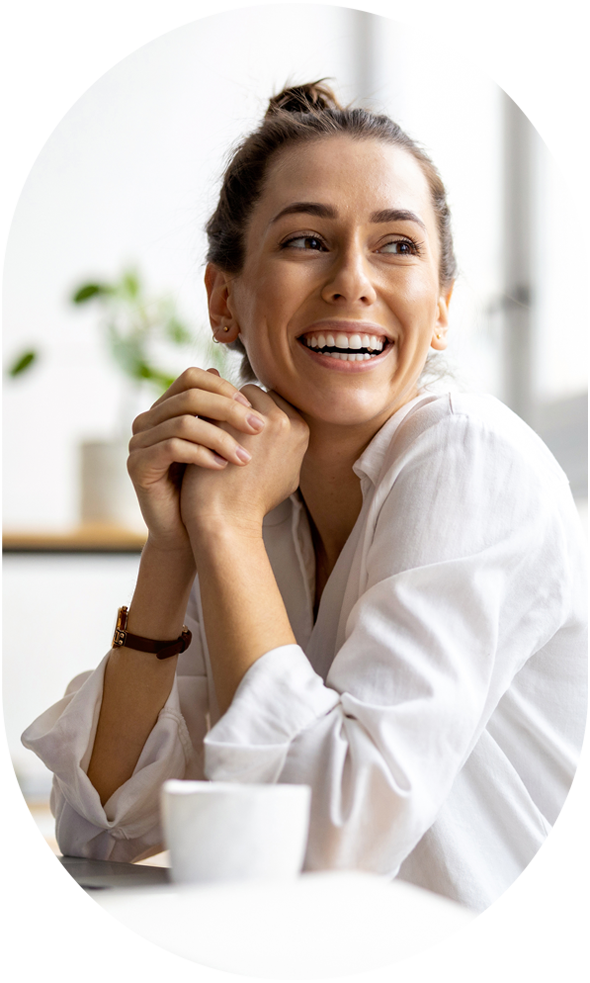 woman sitting with hands together and happily smiling