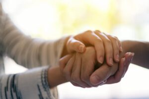 a photo of two people holding each other hands while in a heroin rehab program