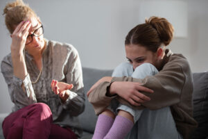 a mother sits with her adult daughter wondering how to support a loved one with an addiction